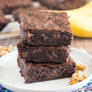 cropped close up banana brownies stacked on a white plate
