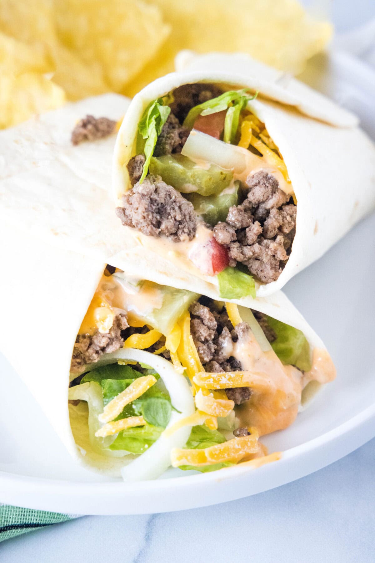 These quick and easy big mac wraps have everything you love about cheeseburgers, but in a healthier wrap form that you can make at home. Close up of a burger wrap leaning on another burger wrap