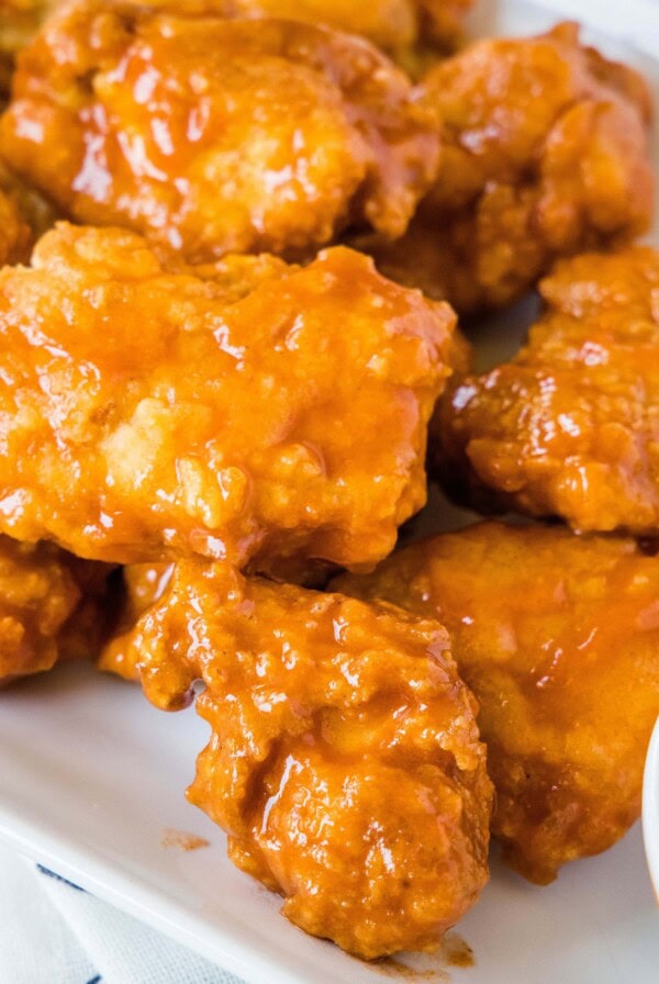 close up boneless chicken wings on a white plate with ranch