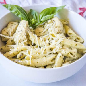 cropped close up of chicken pesto pasta in a white bowl