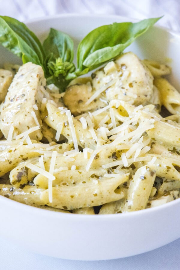 cropped close up of chicken pesto pasta in a white bowl