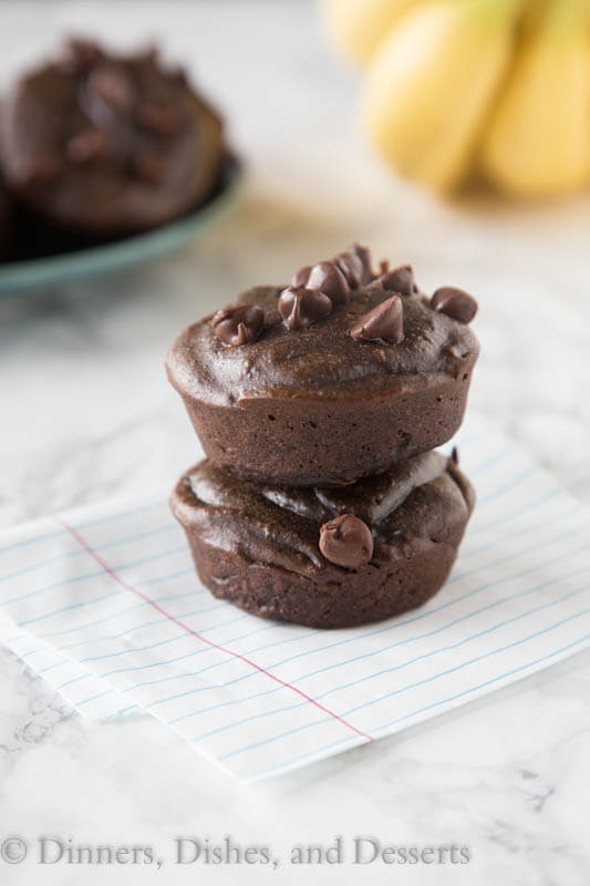 chocolate muffins stacked sitting on top of a table