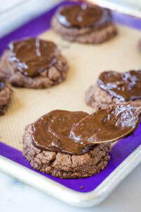 spreading chocolate ganache on cookies