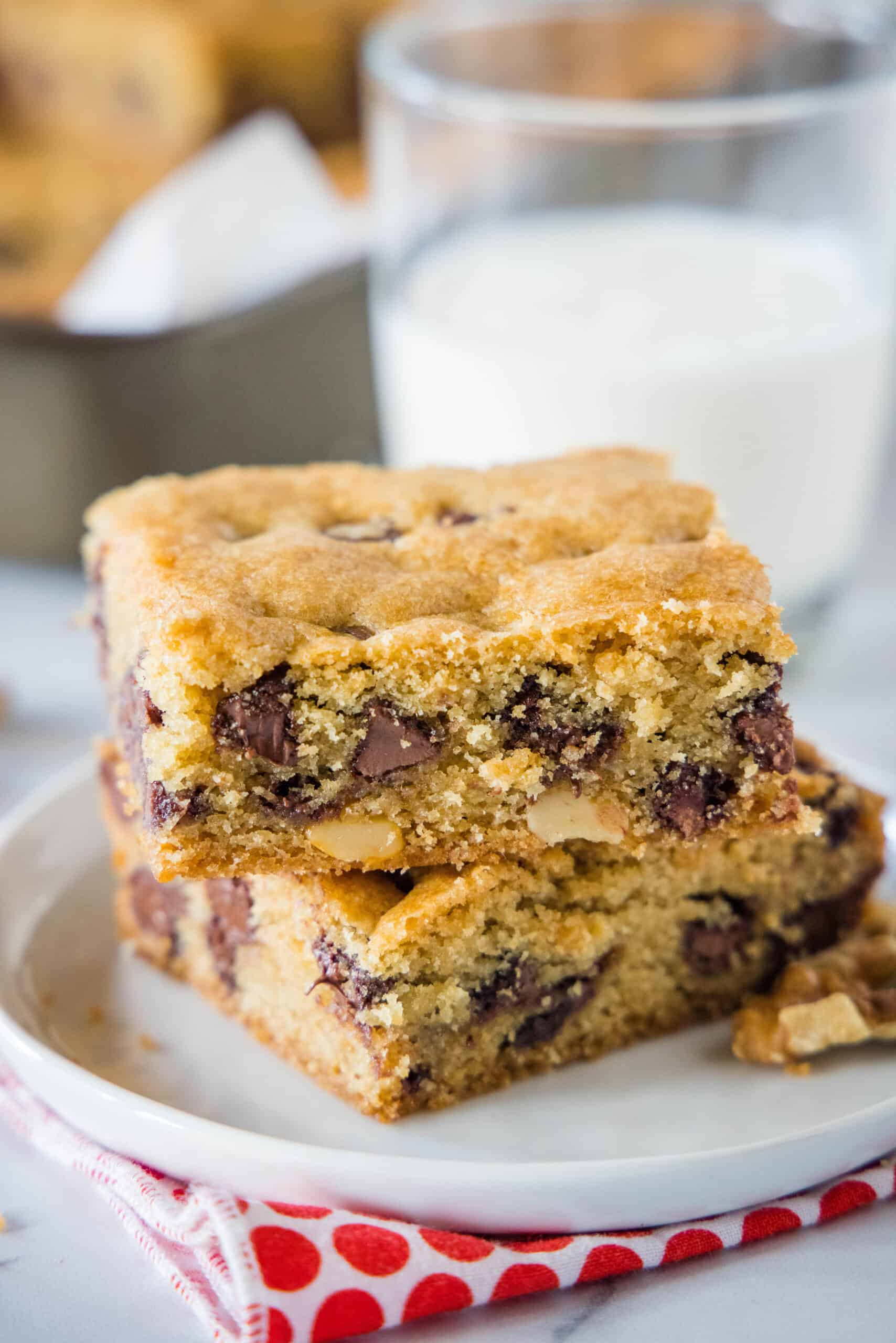 Congo bars are thick and gooey cookie bars loaded with two types of chocolate and crunchy walnuts. Make them in one bowl in minutes! Two Congo bars stacked on a white plate.