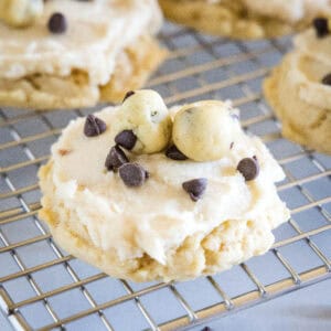 Close up of frosted cookie dough cookies on a wire rack.