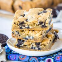 cropped close up of stacked cookies and cream bars stacked on a white plate