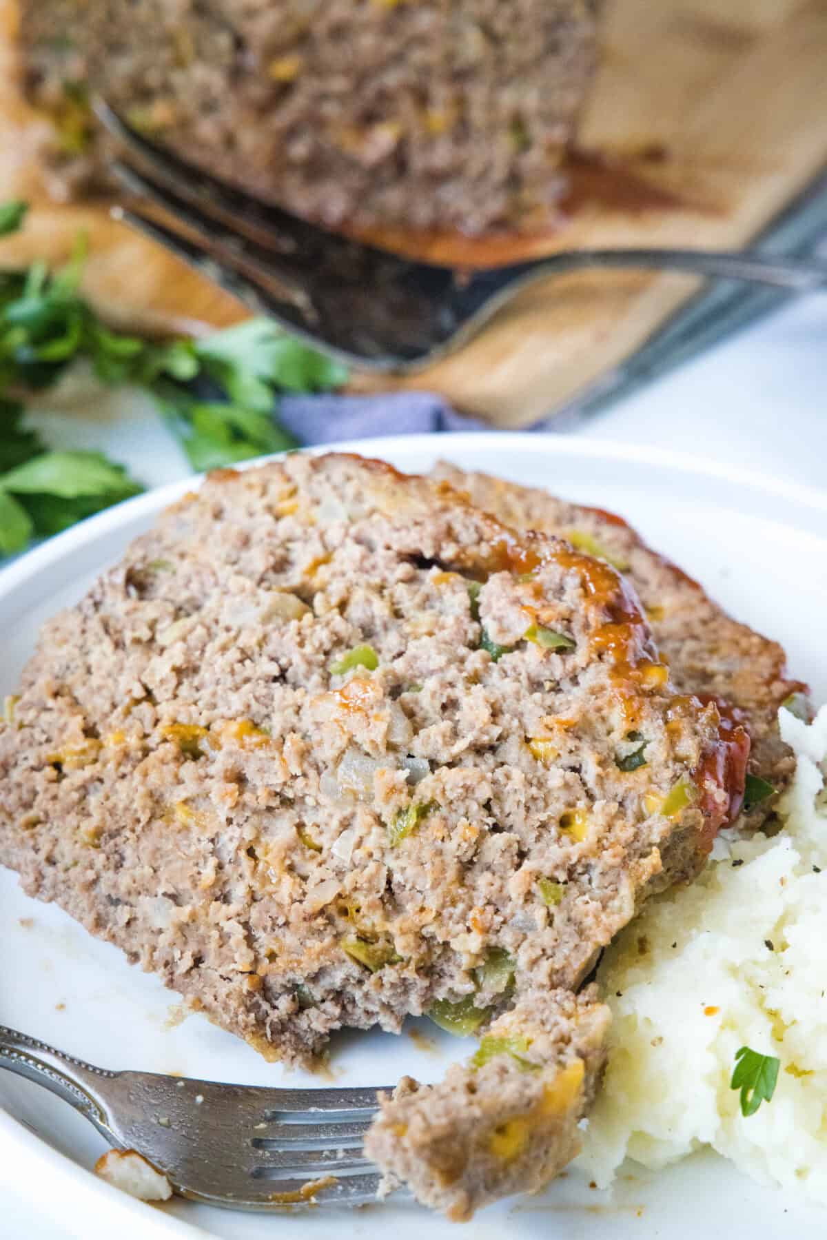looking down on a plate with slice meatloaf and mashed potatoes