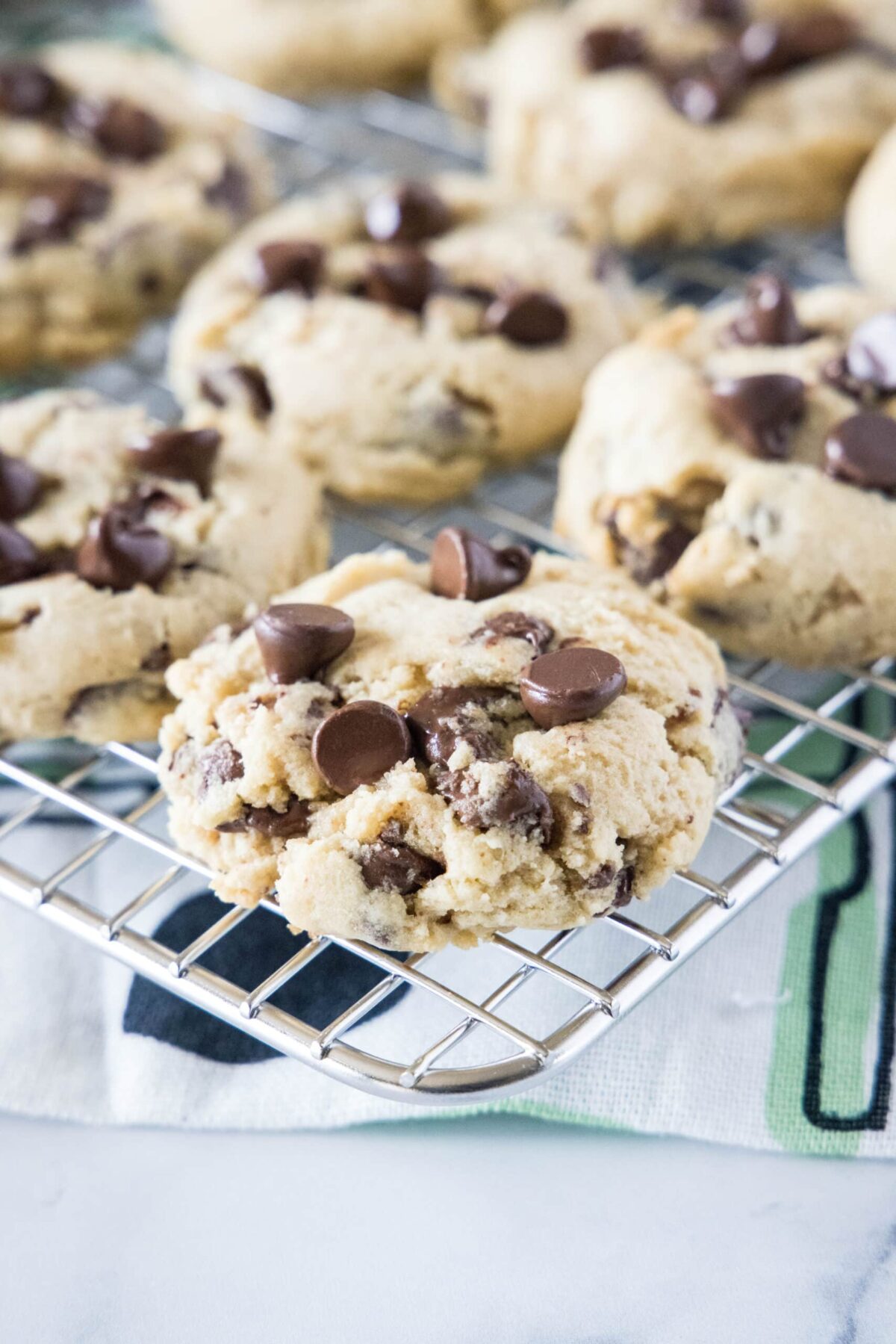 These melt in your mouth cream cheese chocolate chip cookies are decadent, soft, moist, and chewy, and so easy to make. Close up of chocolate chip cookies on a wire rack