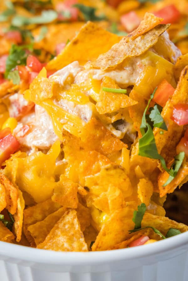 scooping dorito chicken casserole out of dish
