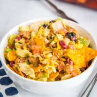 A bowl of food on a plate, with Salad and Taco