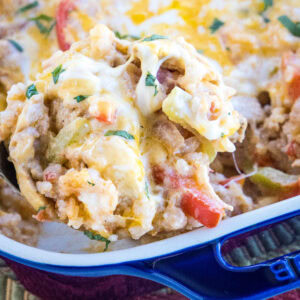 A serving of chicken fajita casserole being scooped from a baking dish.