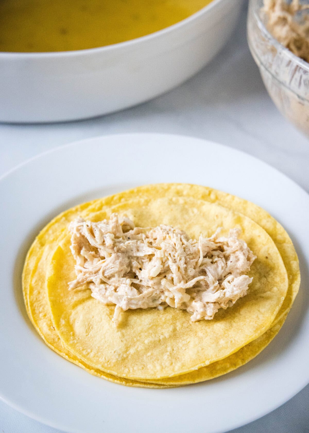 added chicken filling to the center of a corn tortilla