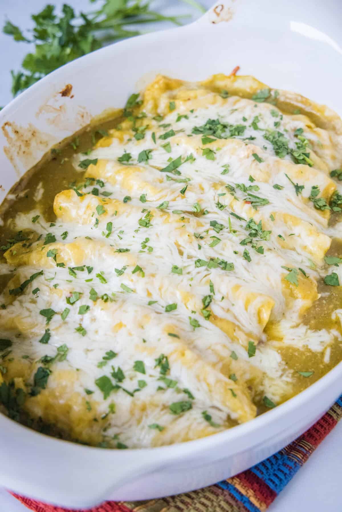 green chile chicken enchiladas in baking dish