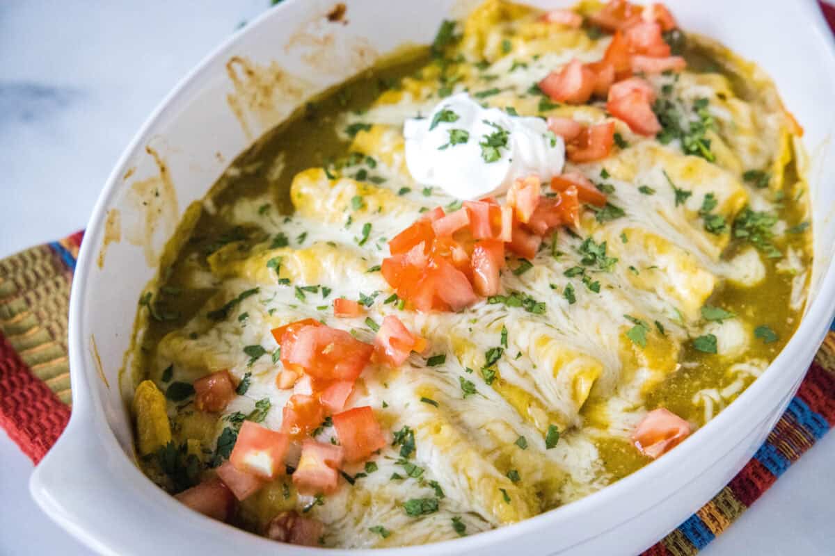 These Green Chile Chicken Enchiladas are creamy, cheesy, and packed with flavor! Made with seasoned shredded chicken, melty cheese, and topped with green chile enchilada sauce.