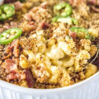 close up spooning mac and cheese from baking dish