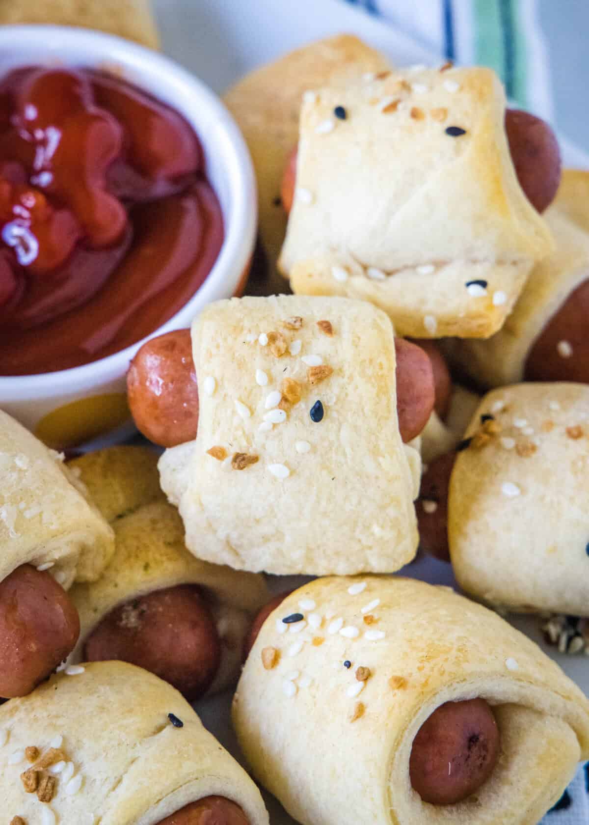 pigs in a blanket on a serving platter with ketchup