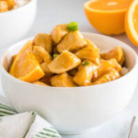 close up orange chicken in a white bowl