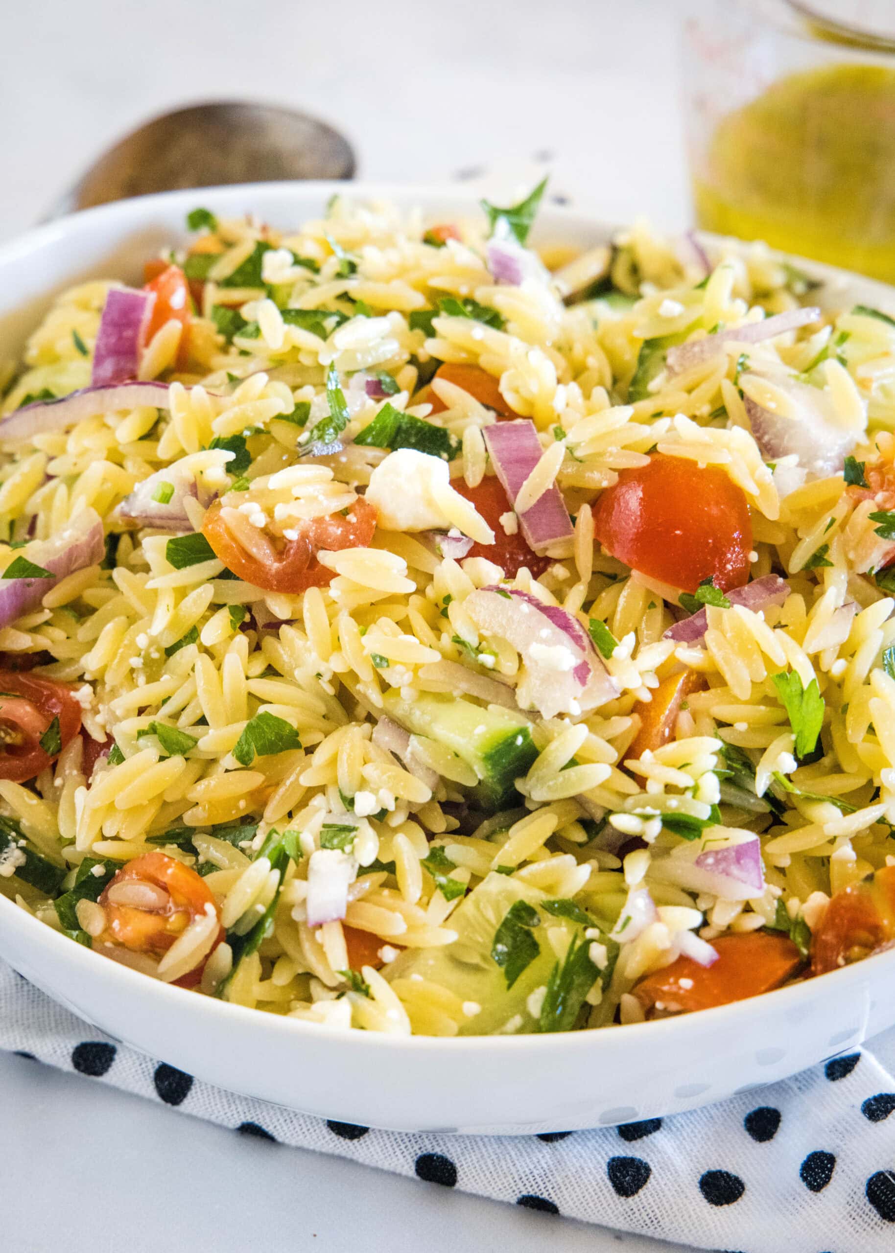 This orzo pasta salad is an easy summer side dish with tender orzo, crunchy cucumber, tomatoes, and feta tossed in a zesty lemon vinaigrette. Orzo pasta salad in a large bowl.
