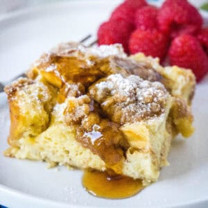 cropped close up overnight french toast casserole topped with syrup