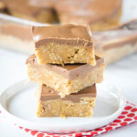 cropped in peanut butter oatmeal bars with chocolate frosting stacked on a plate