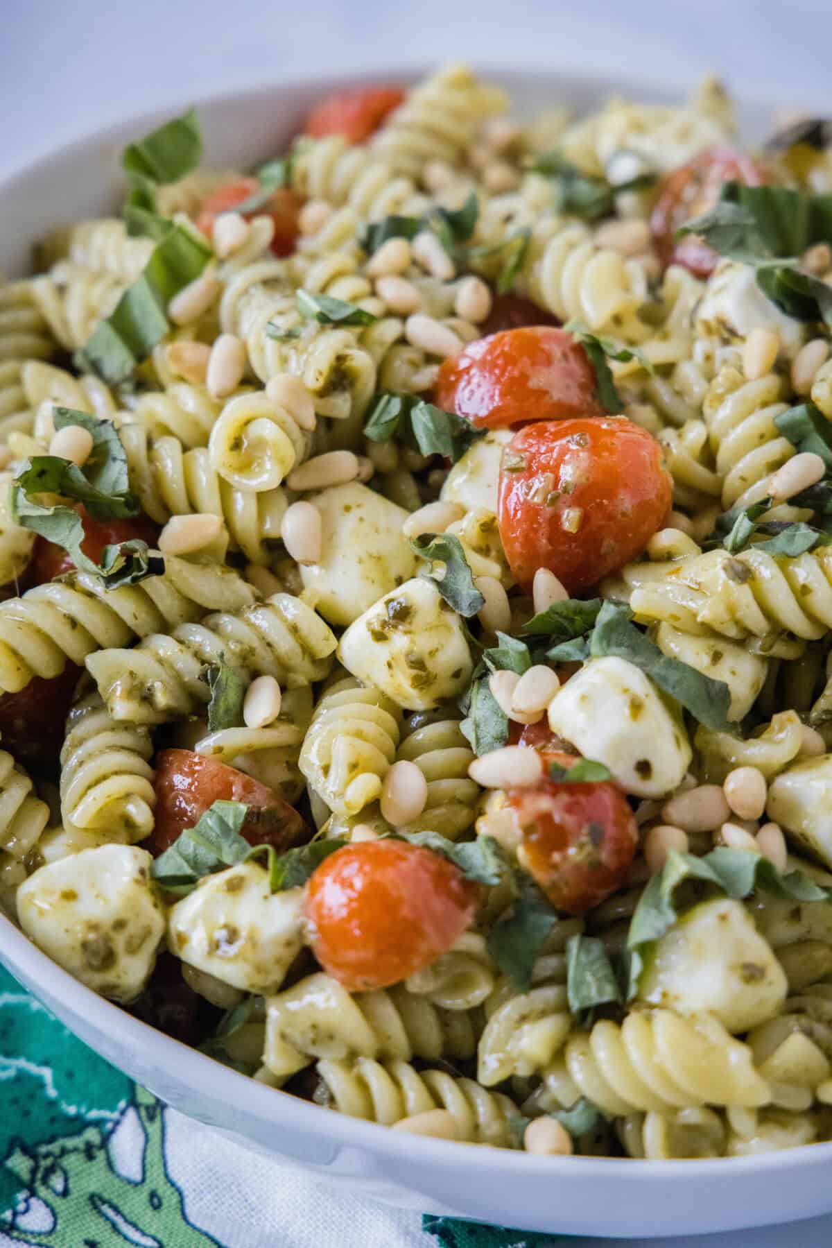a serving bowl with creamy pesto pasta salad
