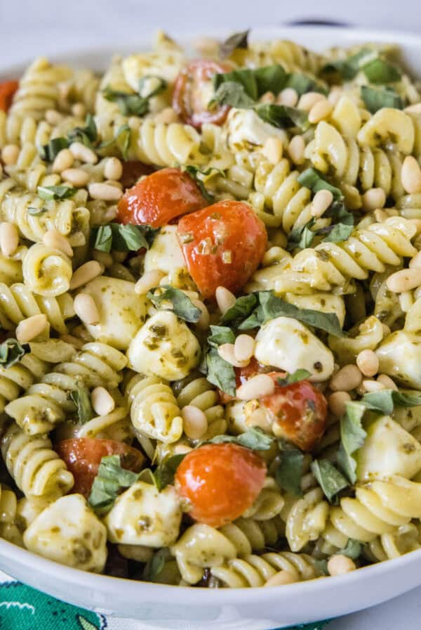 close up pesto pasta salad in a white bowl