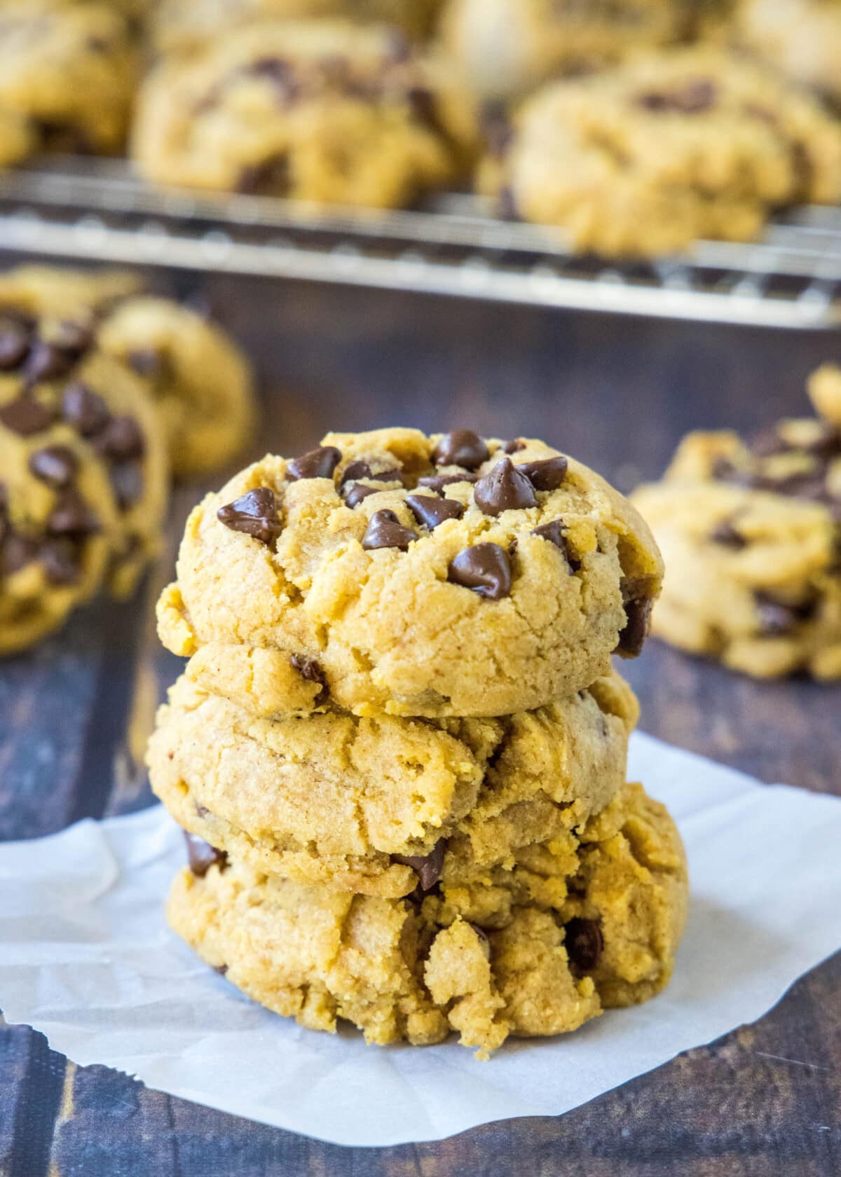 pumpkin chocolate chip cookies stacked on a table