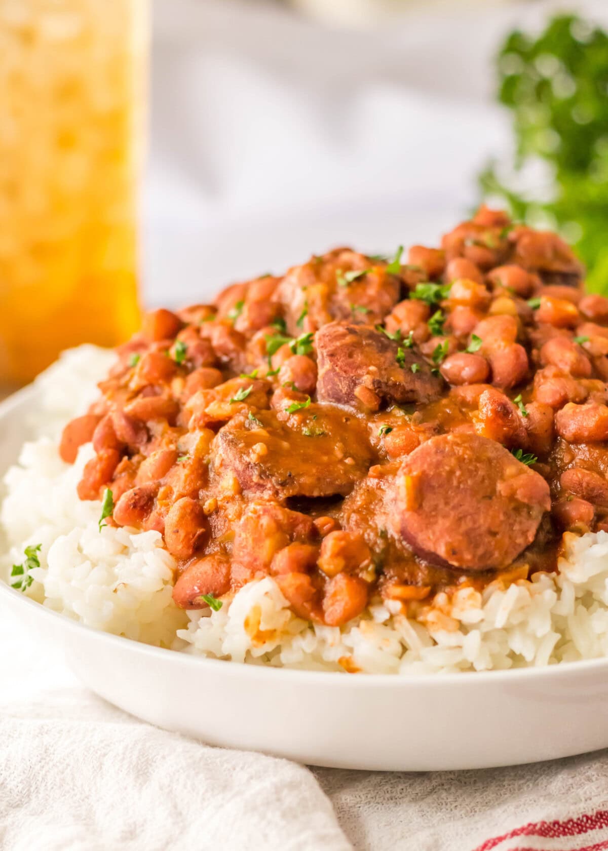 View from the side of a plate of rice topped with red beans and sausage.