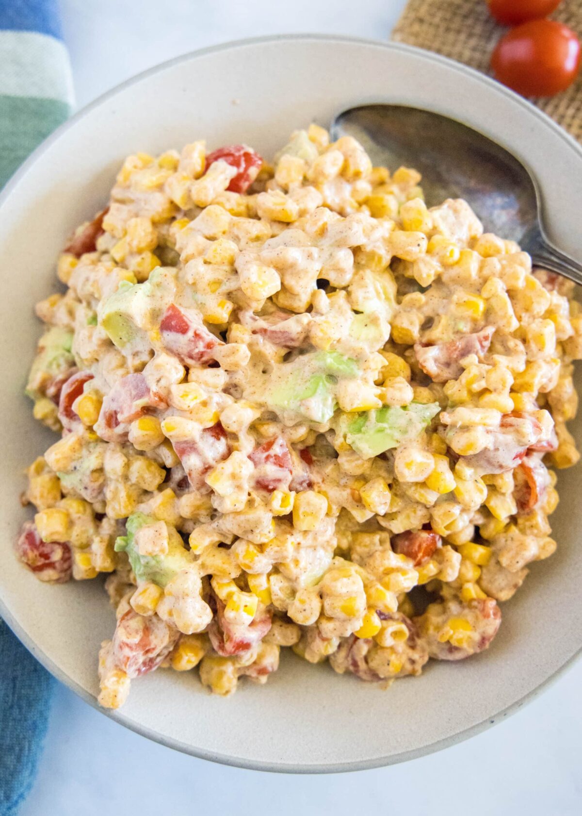 This southwestern corn salad is fresh, tangy, and spicy, and only takes 20 minutes to make. It's the perfect side dish! Overhead view of a bowl of corn salad with a spoon