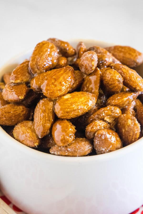 close up spicy honey roasted almonds in white bowl