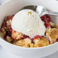 cropped close up strawberry dump cake in a bowl with ice cream
