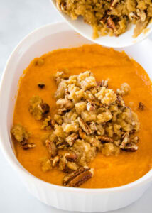 sprinkling crumb topping on sweet potato casserole