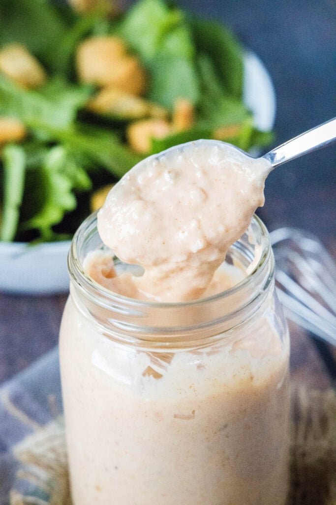 spooining out thousand island dressing from a jar