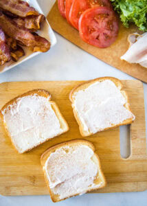 toasted bread with mayo on a cutting board