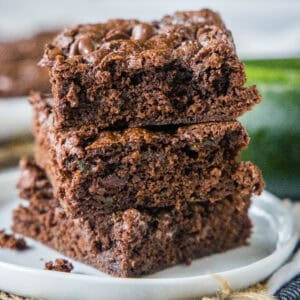 cropped close up stack of zucchini brownies on white plate